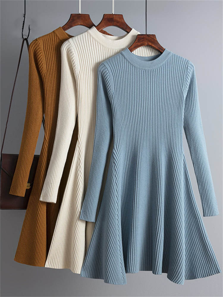 Drei langärmelige Strickkleider, gerippt, in Blau, Creme und Braun, auf Kleiderbügeln.