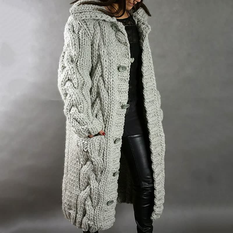 Frau in grauem, grob gestricktem Wollmantel mit Zopfmuster, modisch, warm, Winterkleidung.
