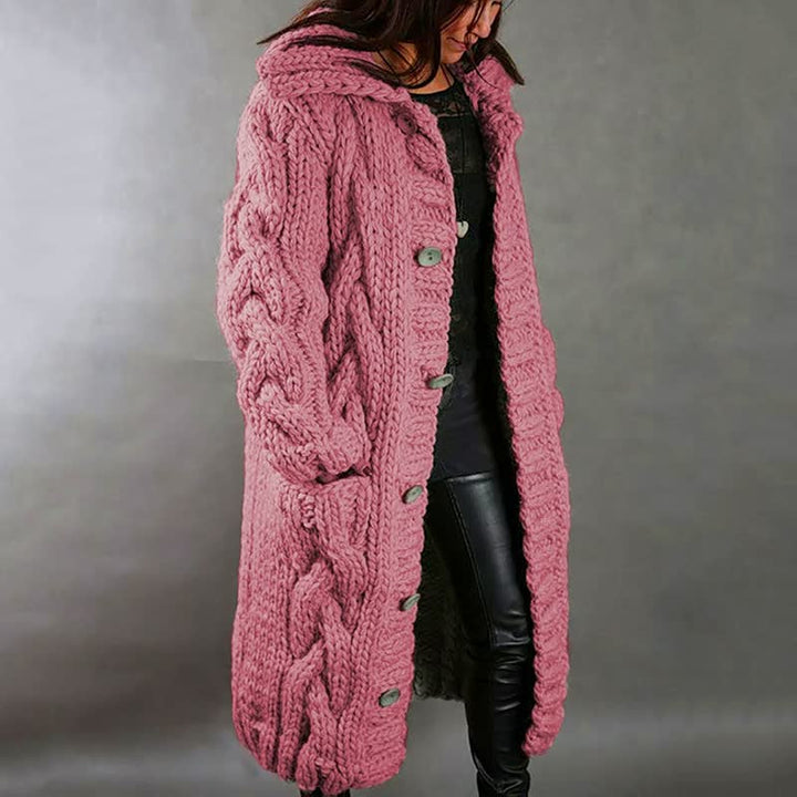 Frau in rosa Strickmantel mit Zopfmuster, Kapuze und Knöpfen, modisch, warm, Winterkleidung.