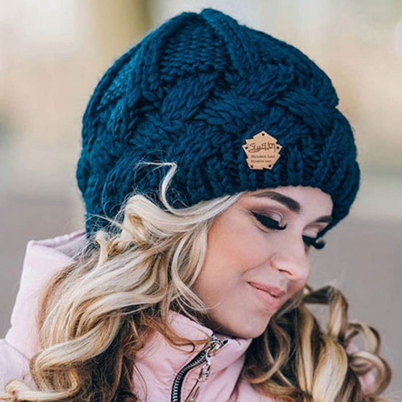 Frau mit blauer Strickmütze, Zopfmuster, Wintermode, warm, stilvoll, Outdoor-Bekleidung.