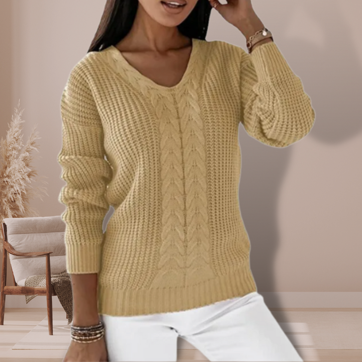 Frau in beigem Strickpullover, V-Ausschnitt, Zopfmuster, modisch, gemütlich, Herbstmode.