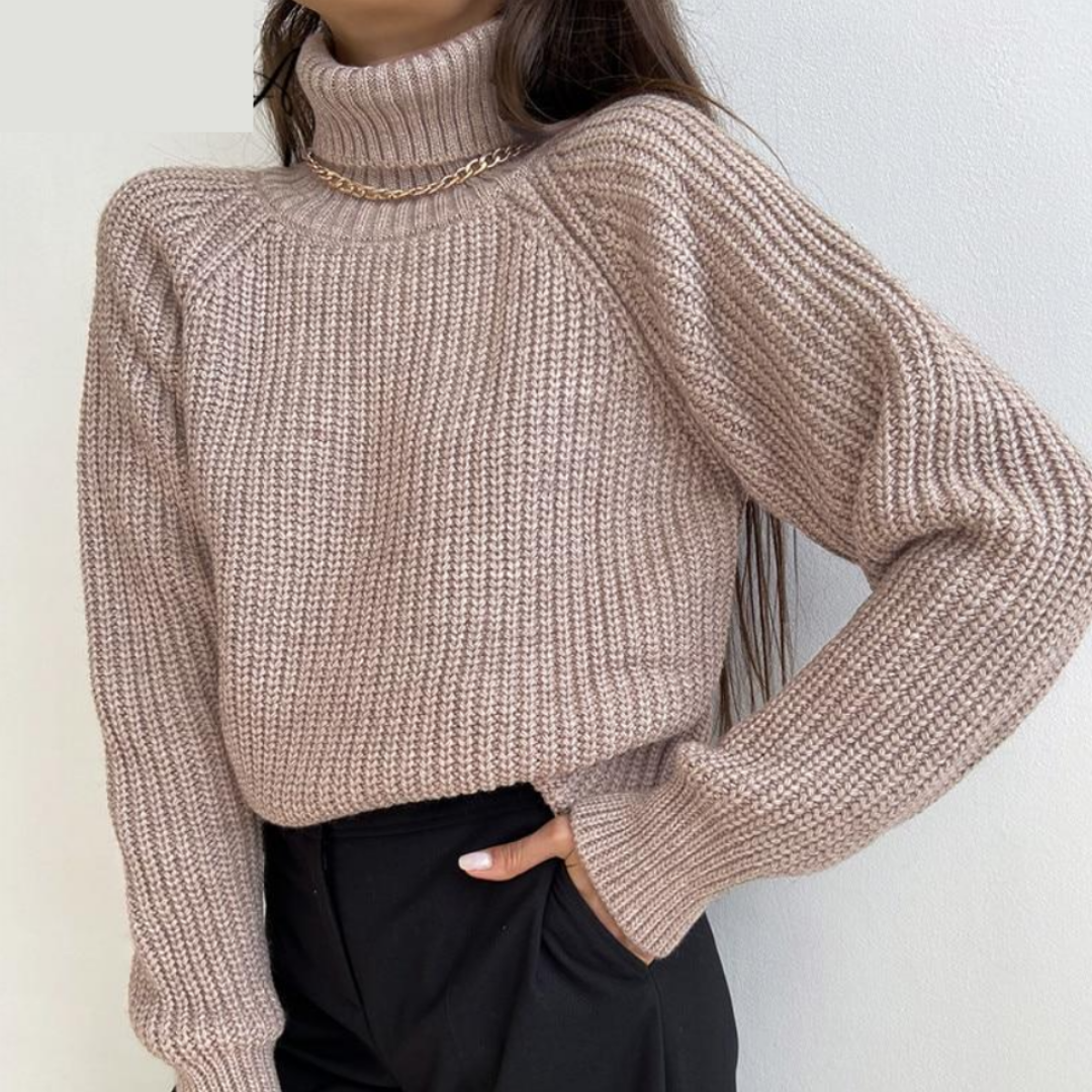 Frau in beigem Strickpullover mit Rollkragen und goldener Kette, modisch, elegant, Herbstmode.