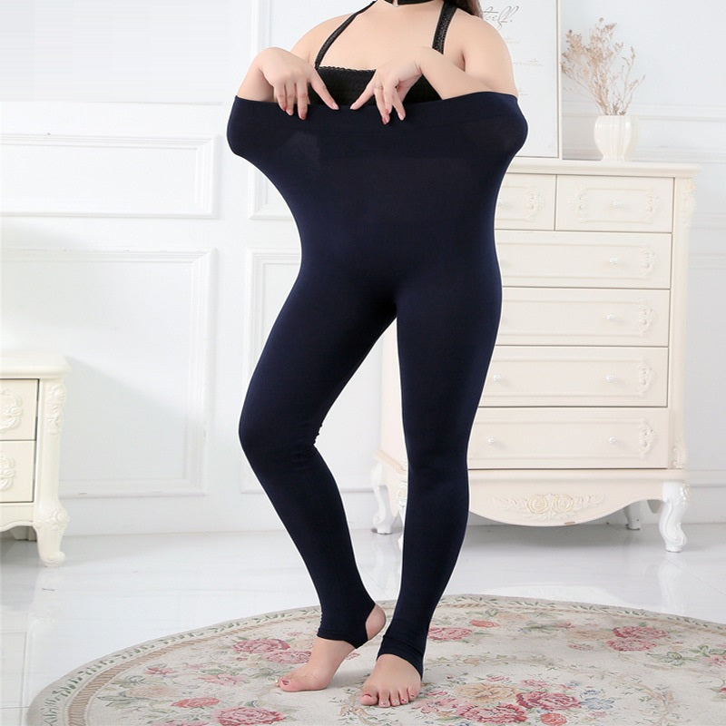 Frau in übergroßer, dunkelblauer Leggings im Wohnzimmer, weiße Kommode im Hintergrund.