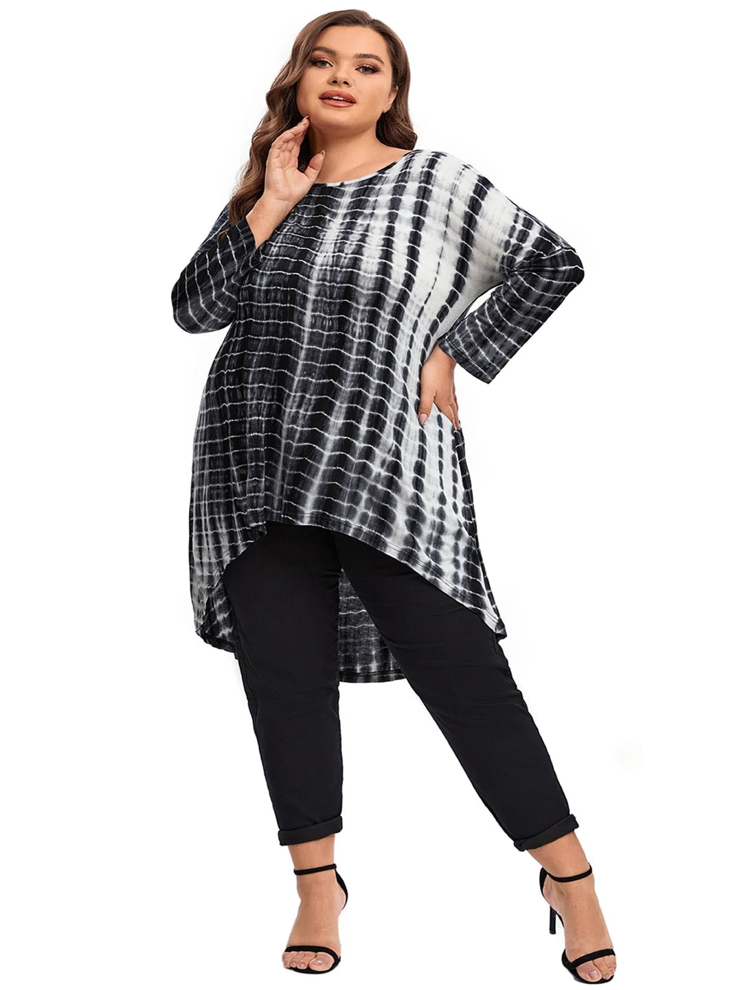 Frau in schwarz-weißem Batik-Tunika-Kleid und schwarzen Hosen, Mode, Plus-Size, elegant.