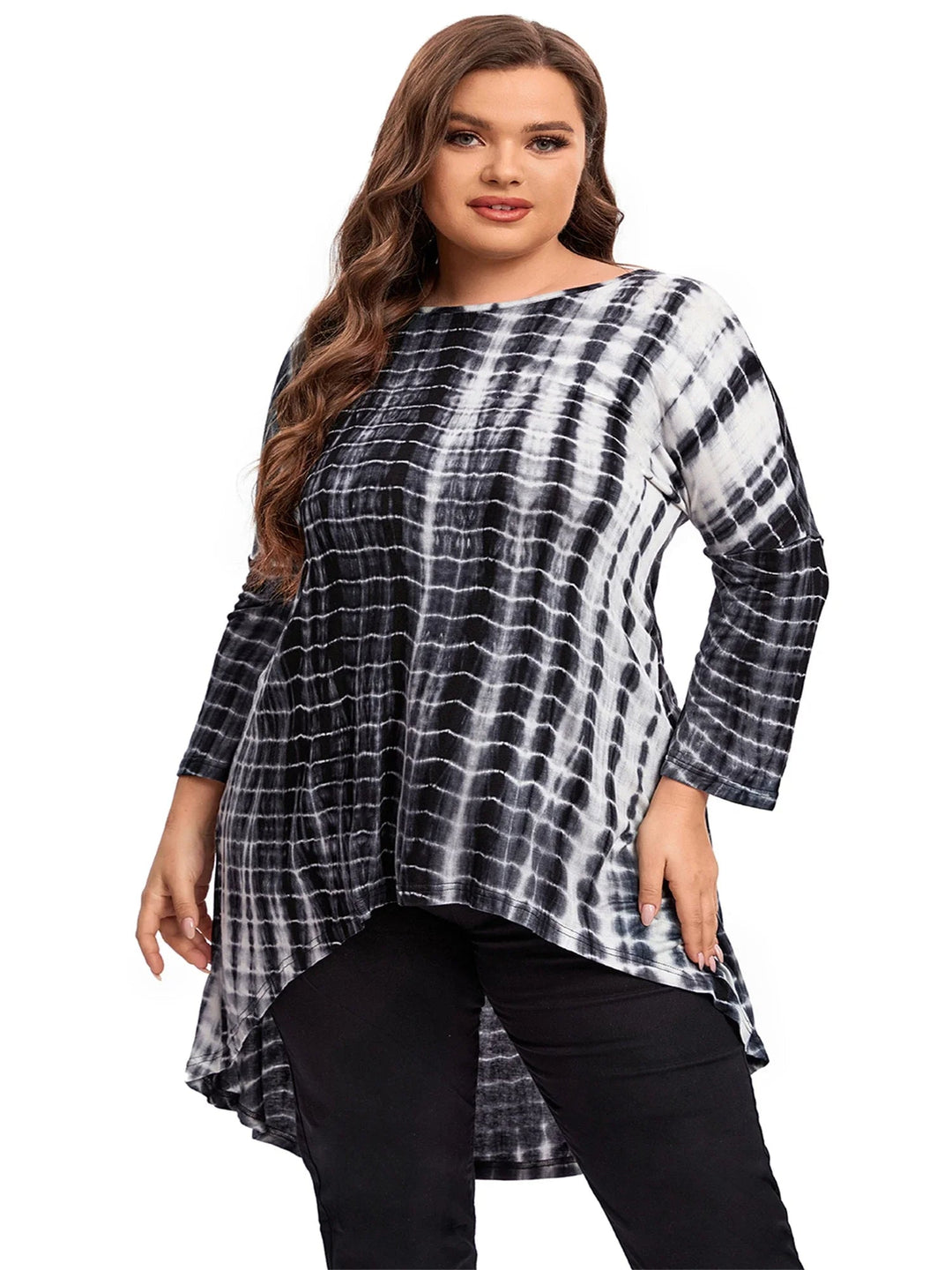 Frau in schwarz-weißem Batik-Longshirt, lange Ärmel, asymmetrischer Saum, Plus-Size-Mode.