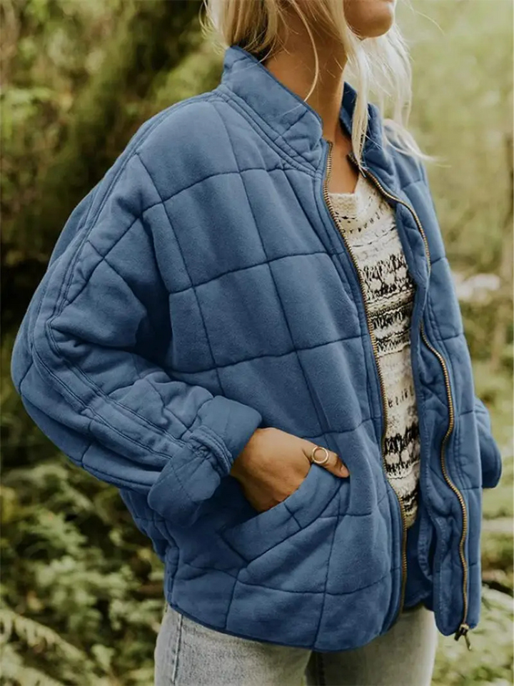 Frau in blauer, gesteppter Übergangsjacke, lässig, modisch, Outdoor, Herbstmode.