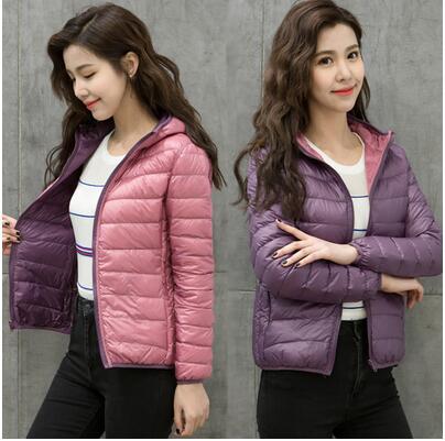 Frau in rosa und lila Daunenjacke, gestreiftes Shirt, lässiger Look, Mode für Damen.