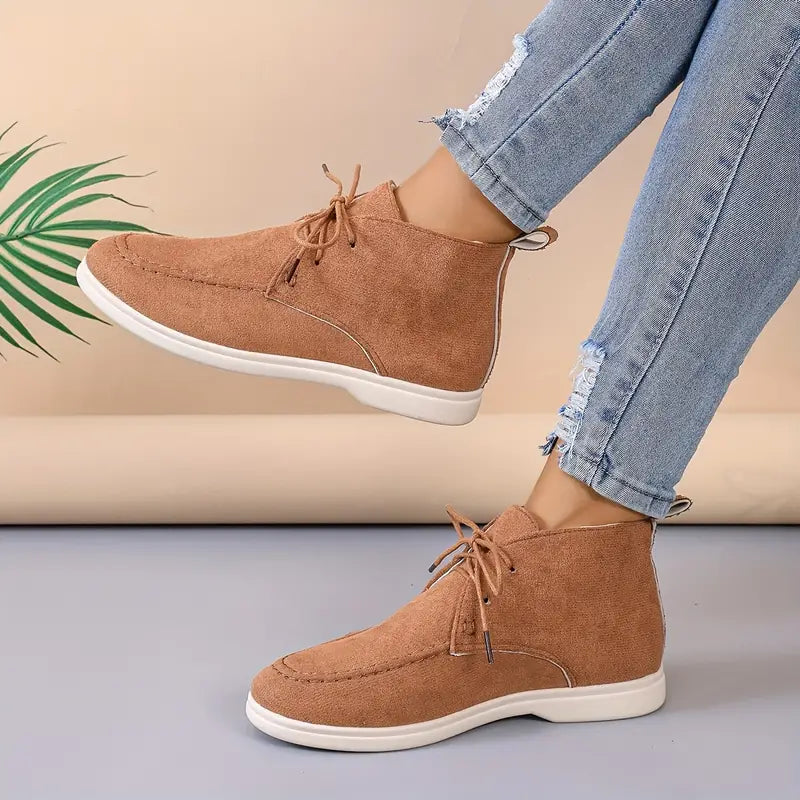 Damen Stiefeletten aus Wildleder in Braun, lässig, mit Schnürung, kombiniert mit zerrissenen Jeans.
