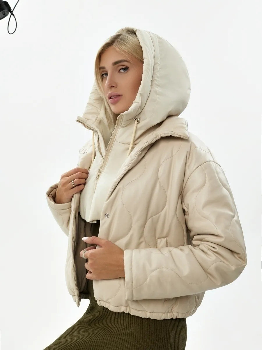 Frau in beiger Steppjacke mit Kapuze, Wintermode, warm, stilvoll, Damenbekleidung.