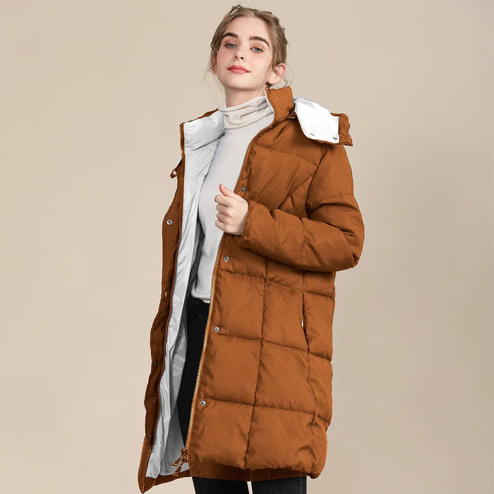 Frau in braunem Daunenmantel mit Kapuze, Wintermode, warm, stilvoll, beige Hintergrund.