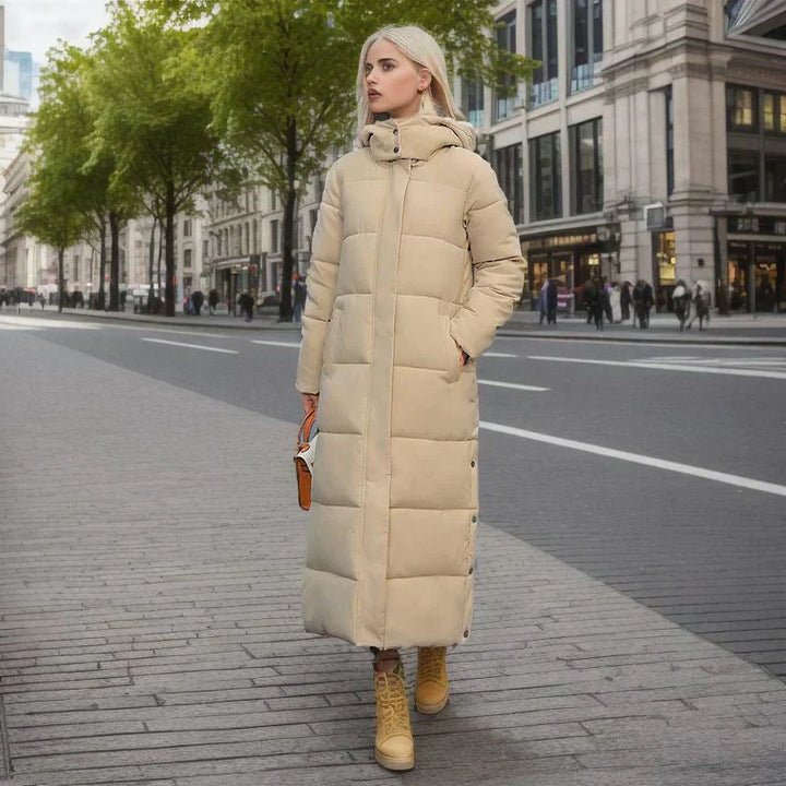 Frau in beigem Daunenmantel auf Stadtstraße, Wintermode, lange Jacke, warme Bekleidung.
