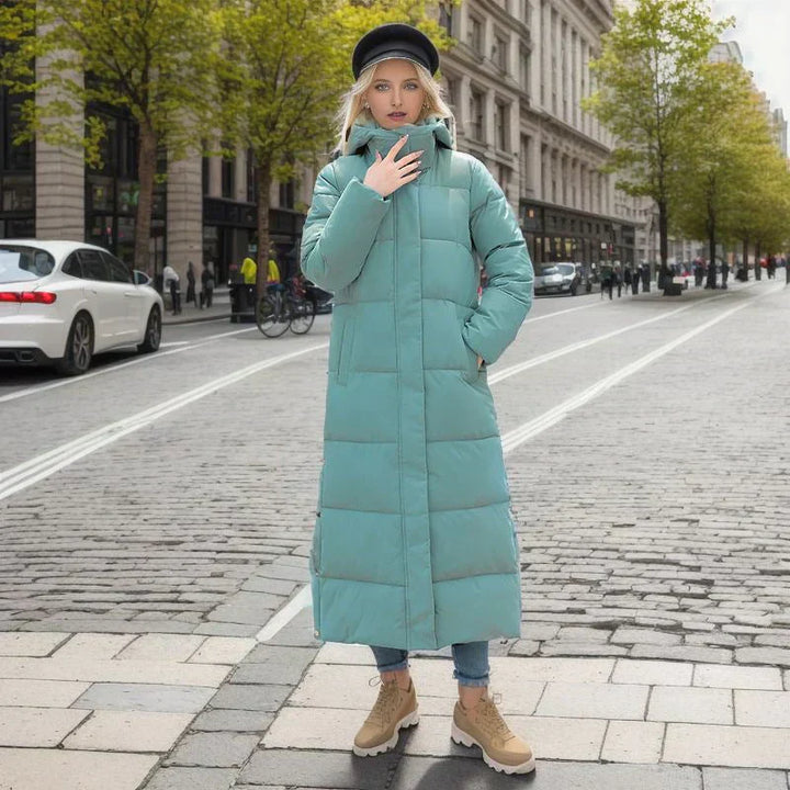 Frau in türkisfarbener Daunenjacke auf städtischer Straße, Herbstmode, warme Winterbekleidung.