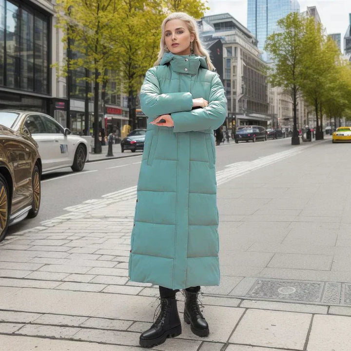 Frau in langem, mintgrünem Daunenmantel auf Stadtstraße, Herbstmode, moderne Kleidung.