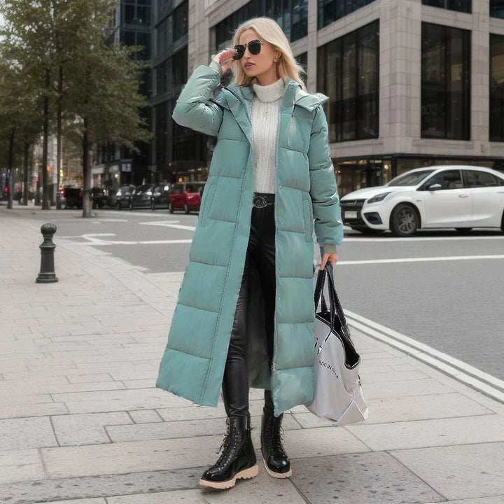 Frau in mintgrünem Daunenmantel, weiße Rollkragenpullover, schwarze Lederhose, Stadtstraße.