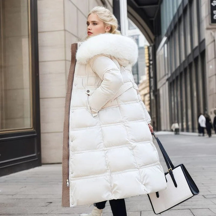 Frau in weißem Daunenmantel mit Fellkapuze, eleganter Winterlook, Stadtstraße.
