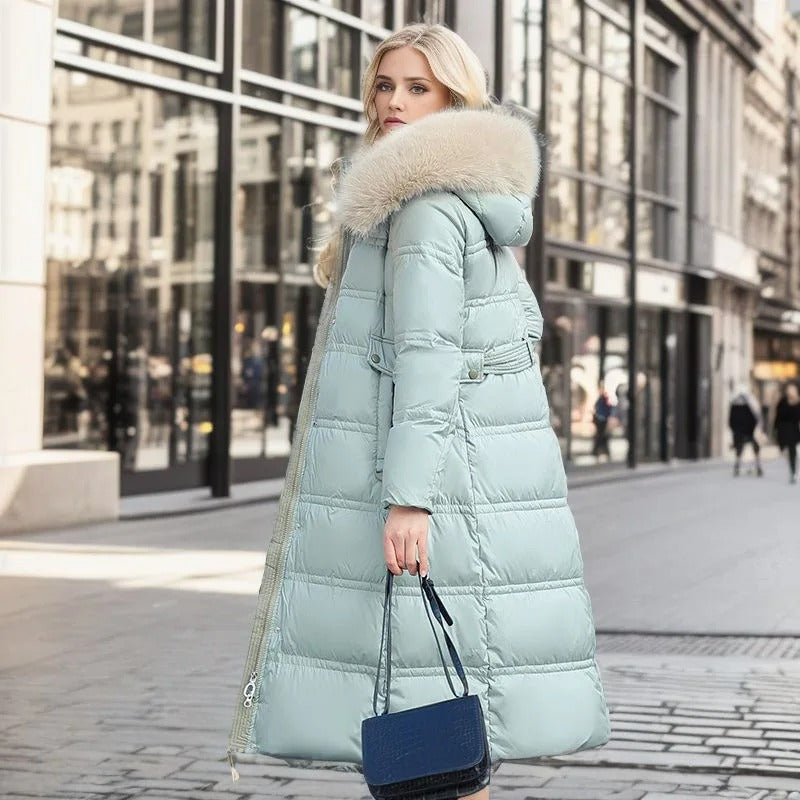 Frau in hellblauem Daunenmantel mit Fellkapuze, Stadtstraße, Wintermode, Handtasche.