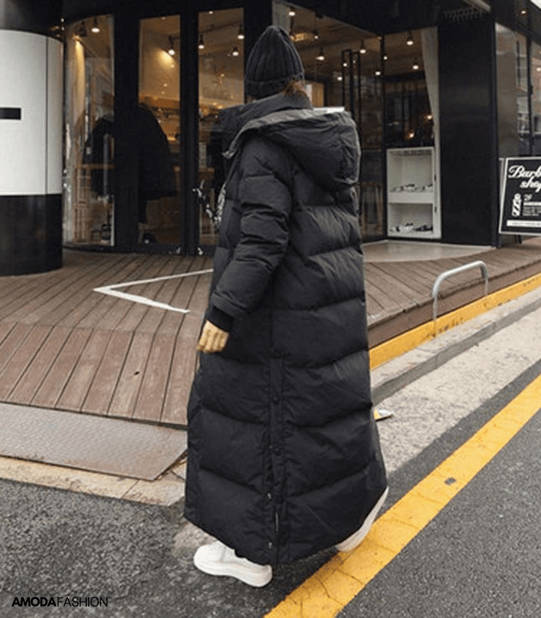 Frau in schwarzem, übergroßem Parka-Wintermantel, Kapuze, Straße, Amodafashion.