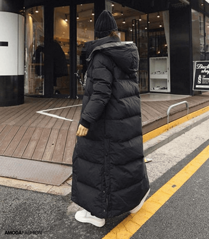 Frau in schwarzem, übergroßem Parka-Wintermantel, Kapuze, Straße, Amodafashion.