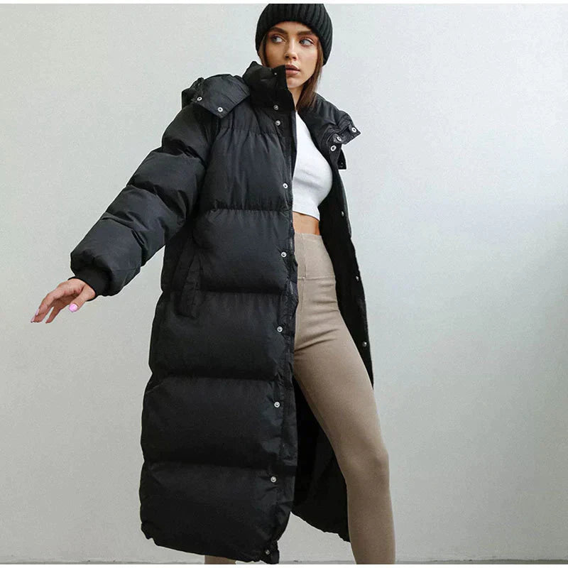 Frau in schwarzem Daunenmantel, Wintermode, lange Jacke, warm, stilvoll, modern, Outdoor-Bekleidung.