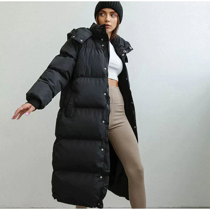 Frau in schwarzem Daunenmantel, Wintermode, lange Jacke, warm, stilvoll, modern, Outdoor-Bekleidung.