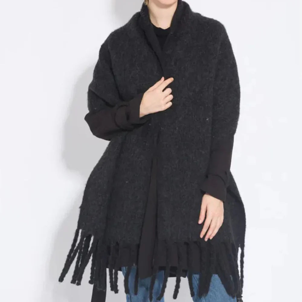 Frau trägt schwarzen Wollponcho mit Fransen, lässiger Herbstmode, Damenbekleidung.