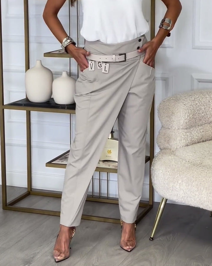 Frau in beigen Wickelhose und weißem Top, modisch, elegant, moderne Damenmode, Wohnzimmer.