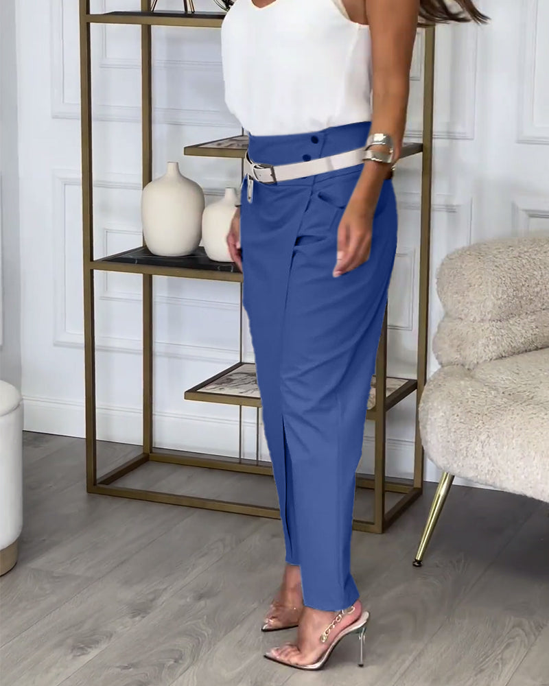 Weiße Bluse und blaue Hose, Damenmode, eleganter Look, Wohnzimmer, moderne Einrichtung.