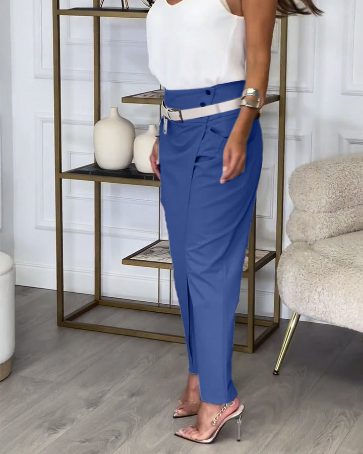 Weiße Bluse und blaue Hose, Damenmode, eleganter Look, Wohnzimmer, moderne Einrichtung.
