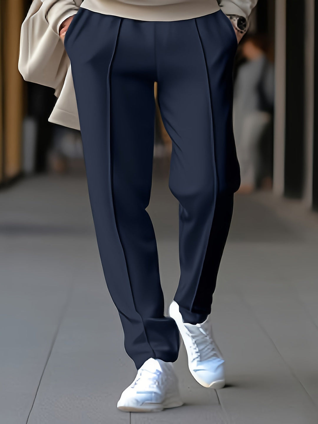 Dunkelblaue Damenhose, elegant, mit weißen Sneakern, modisch, urbaner Stil.