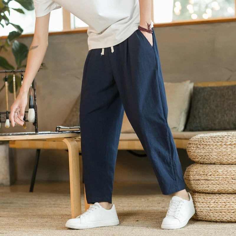 Dunkelblaue Leinenhose, lässig, bequem, Herrenmode, Freizeitkleidung, mit weißen Sneakers.