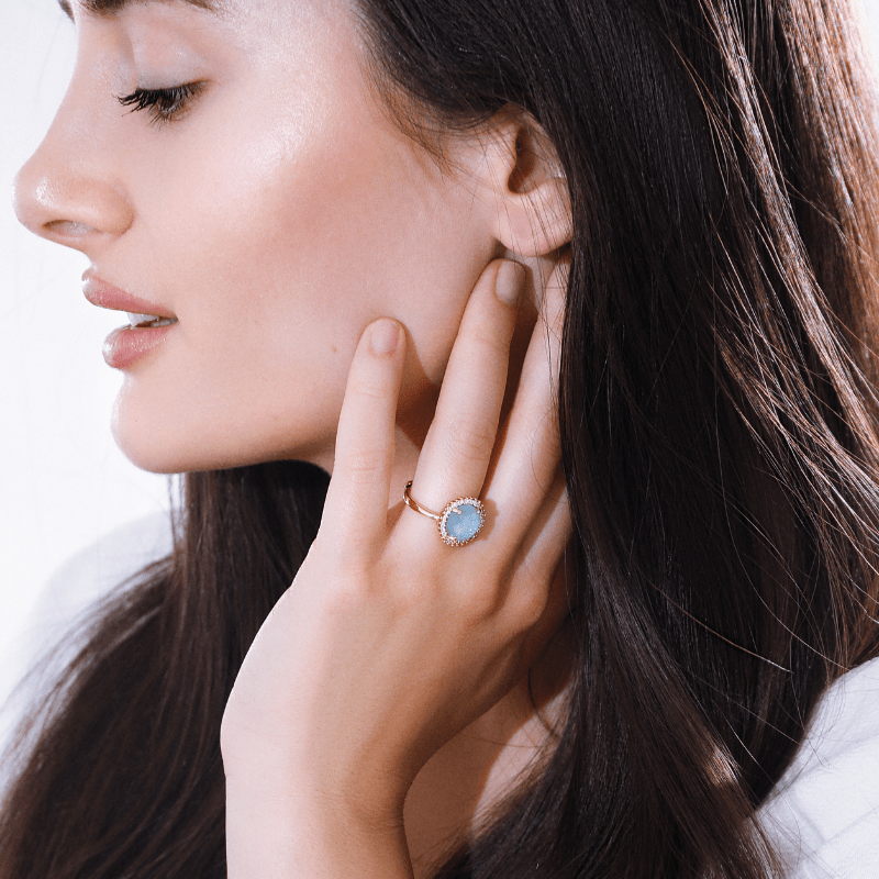 Frau mit blauem Edelsteinring, eleganter Schmuck, Nahaufnahme, Modeaccessoire, stilvoll.
