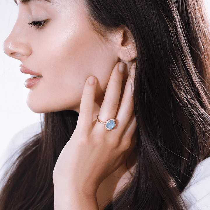 Frau mit blauem Edelsteinring, eleganter Schmuck, Nahaufnahme, Modeaccessoire, stilvoll.