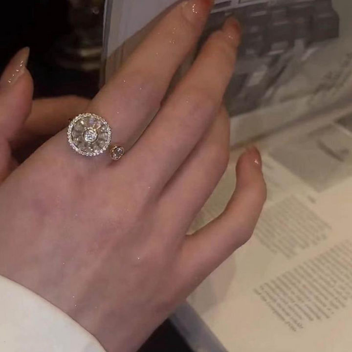 Hand mit funkelndem Diamantring, rund, Silber, beim Blättern in einem Buch.