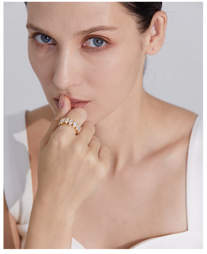 Frau mit goldfarbenem Ring, besetzt mit weißen Steinen, elegantes Schmuckdesign, Nahaufnahme.