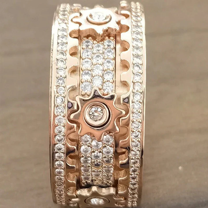 Roségoldener Ring mit Zahnrädern und Diamanten, luxuriöses Schmuckdesign, funkelndes Accessoire.