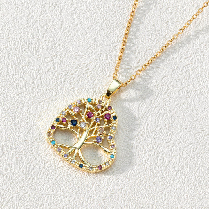 Goldene Halskette mit Lebensbaum-Anhänger, bunte Edelsteine, elegantes Schmuckdesign.