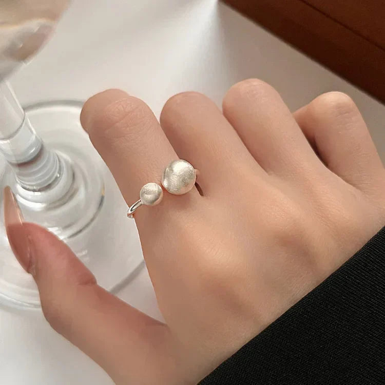 Silberner Doppelperlenring an Hand, eleganter Schmuck, minimalistisches Design, Damenmode.