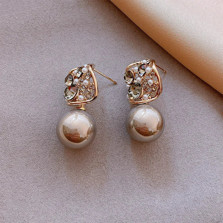 Goldene Ohrringe mit Perlen und Kristallen, eleganter Schmuck, modisches Accessoire für Damen.