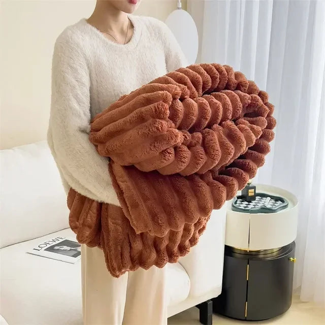 Flauschige braune Kunstfell-Decke, weich, warm, ideal für Herbst und Winter, auf Sofa drapiert.