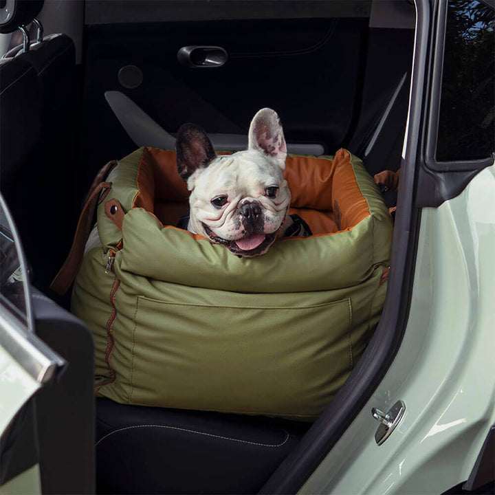 Französische Bulldogge im grünen Kunstleder-Autositz für Hunde im Auto.