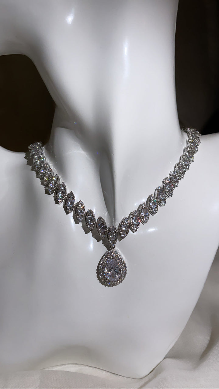 Luxuriöse Diamant-Halskette mit ovalen Steinen und rundem Anhänger auf weißem Hintergrund.