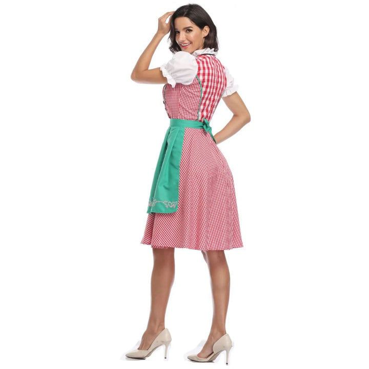 Frau im rot-weiß karierten Dirndl mit grüner Schürze, traditionelles bayerisches Kleid.