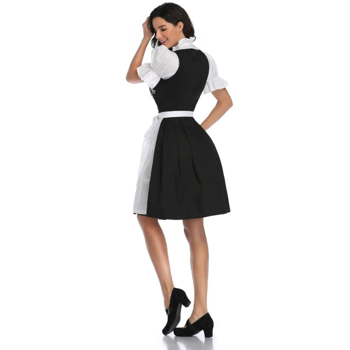 Frau in schwarzem Dirndl mit weißer Bluse, traditionelles bayerisches Kleid, Rückansicht.