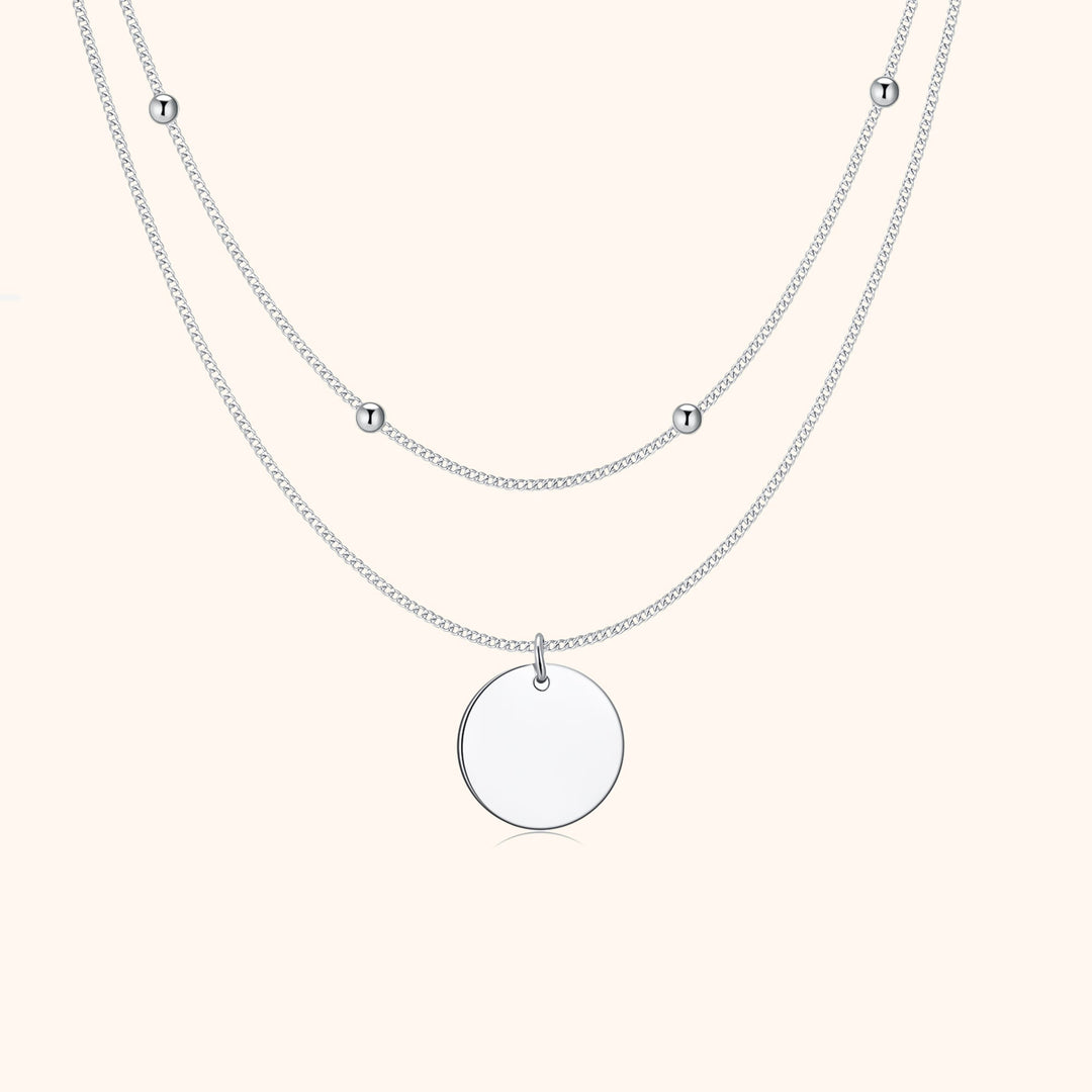 Silberne Halskette mit rundem Anhänger und kleinen Kugeln, elegantes Schmuckdesign.