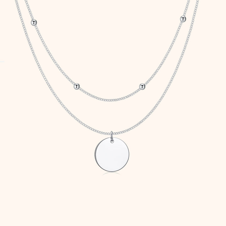 Silberne Halskette mit rundem Anhänger und kleinen Kugeln, elegantes Schmuckdesign.