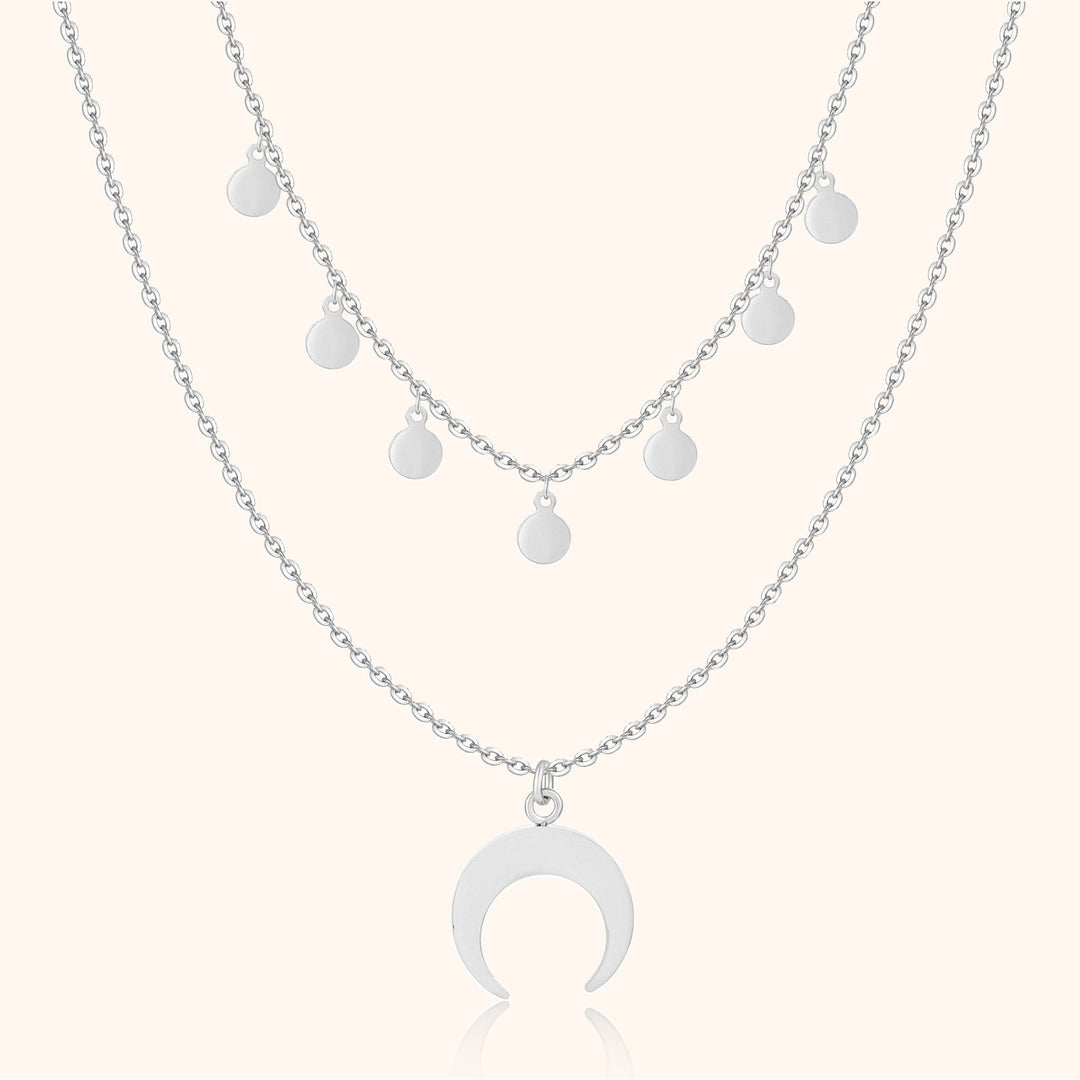 Silberne Halskette mit Halbmond-Anhänger und runden Anhängern, modisches Schmuckdesign.