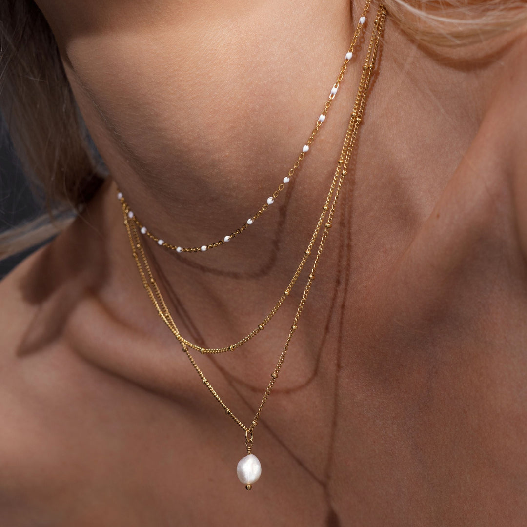 Doppellagige goldene Choker-Halskette mit Perlenanhänger, eleganter Schmuck für Damen.