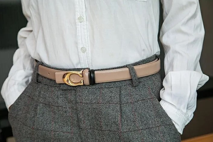Dünner, beidseitiger Gürtel mit C-Schnalle, beige, an grauer Hose und weißem Hemd getragen.