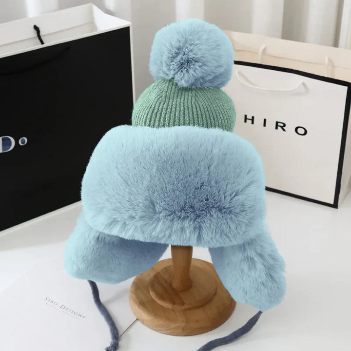 Blaue Plüschmütze mit Bommel, Winteraccessoire, warm, stilvoll, für kalte Tage.