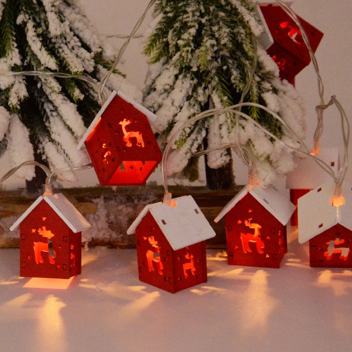 Rote LED-Lichterkette mit Rentiermotiven, weihnachtliche Dekoration, Schneetannen im Hintergrund.